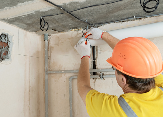 Worker in safety gear assessing HVAC connections